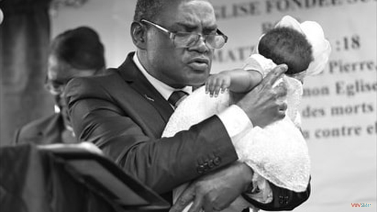 Pastor Laguerre holding baby